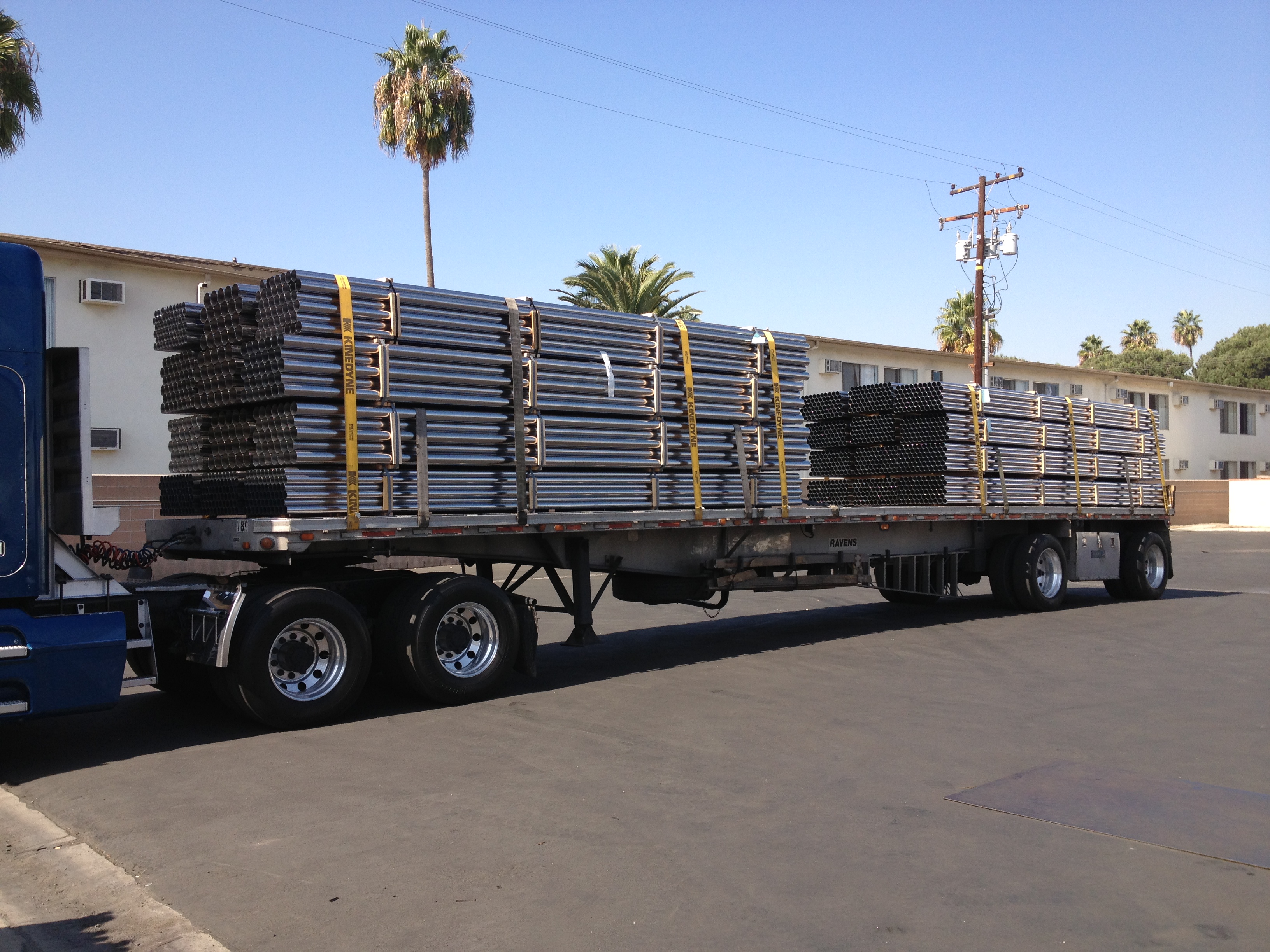 Flatbed truck carrying banded stainless steel tubes